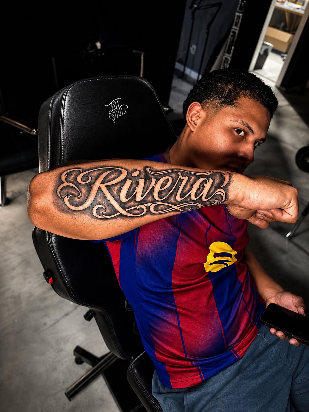 Script lettering 'Rivera' lettering tattoo on the forearm by Junior Sanchez Dfw