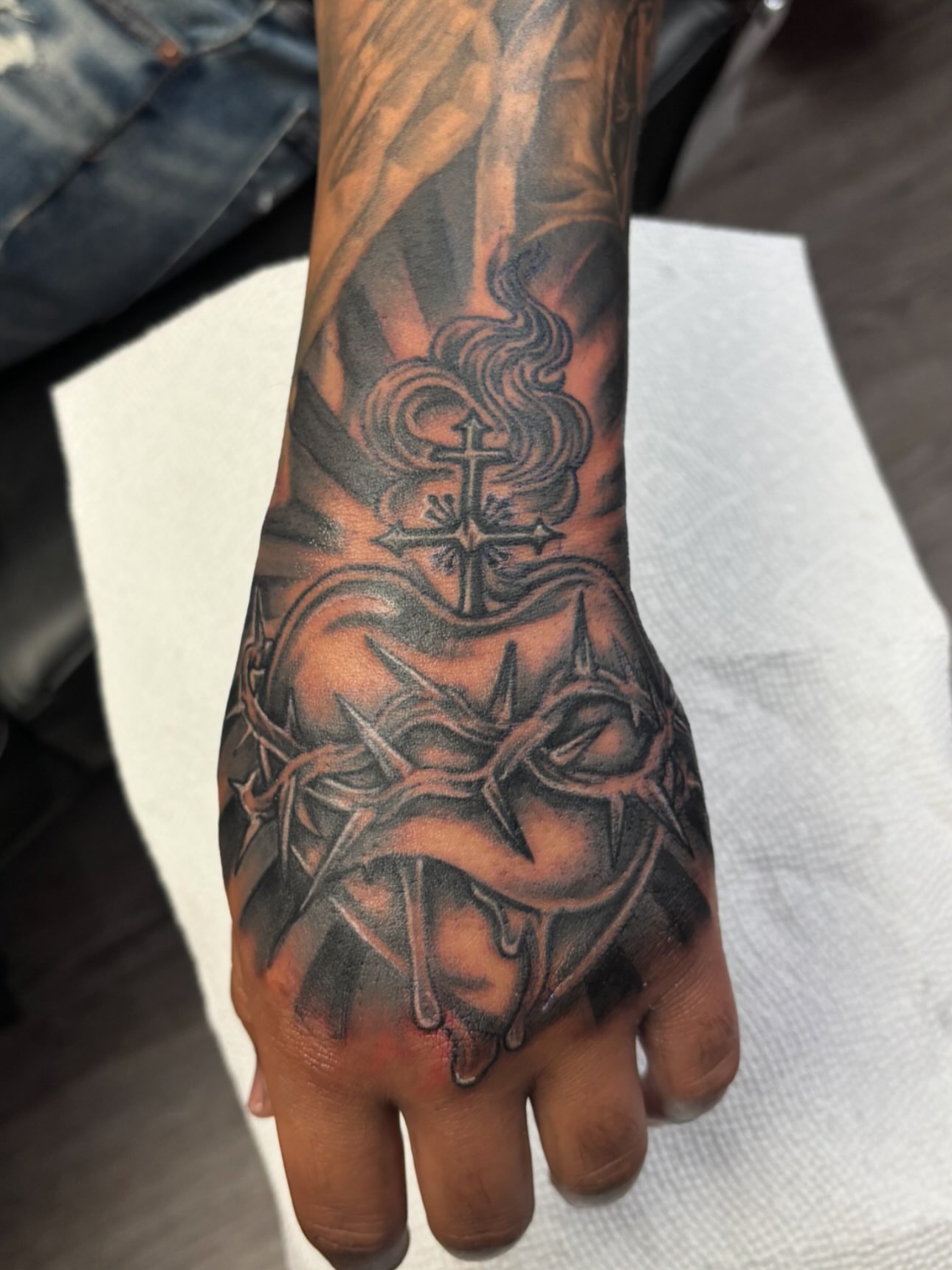 Cross and crown of thorns realism tattoo on the hand by Jesus Pubert Munster