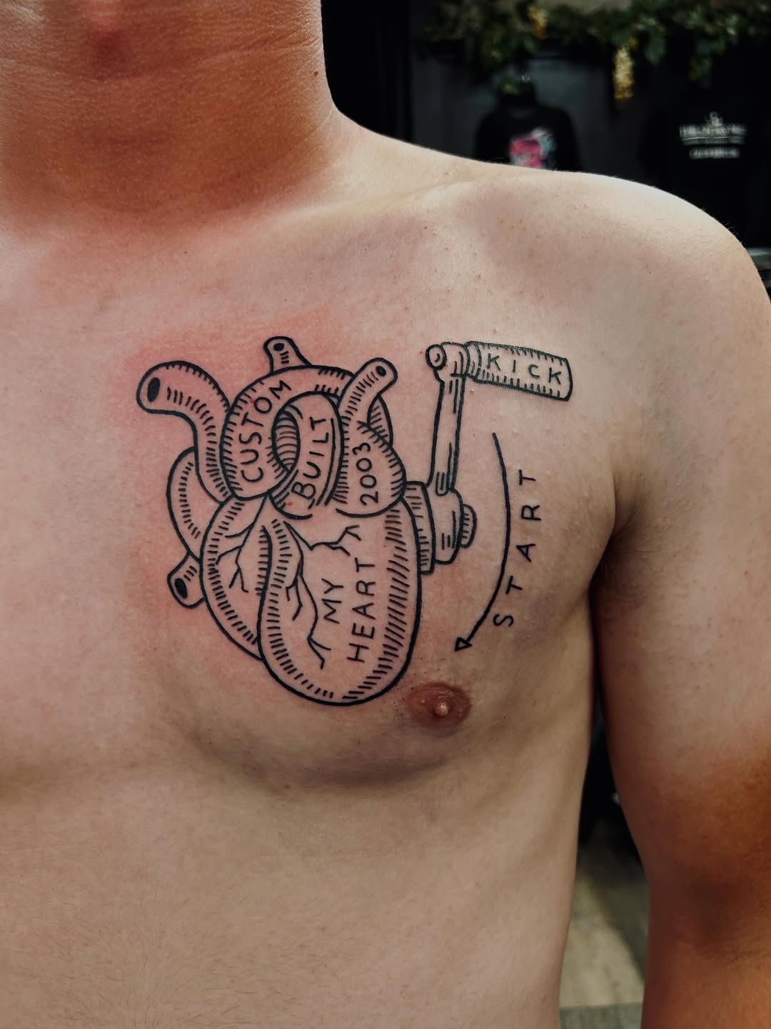 Anatomical heart with kickstart lever tattoo on the chest by Bjorn Bjornstad, Dubuque, Iowa