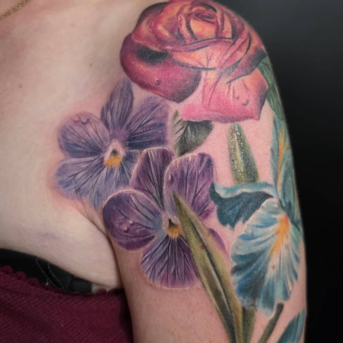 Floral arrangement realism tattoo on the upper arm by Kosta