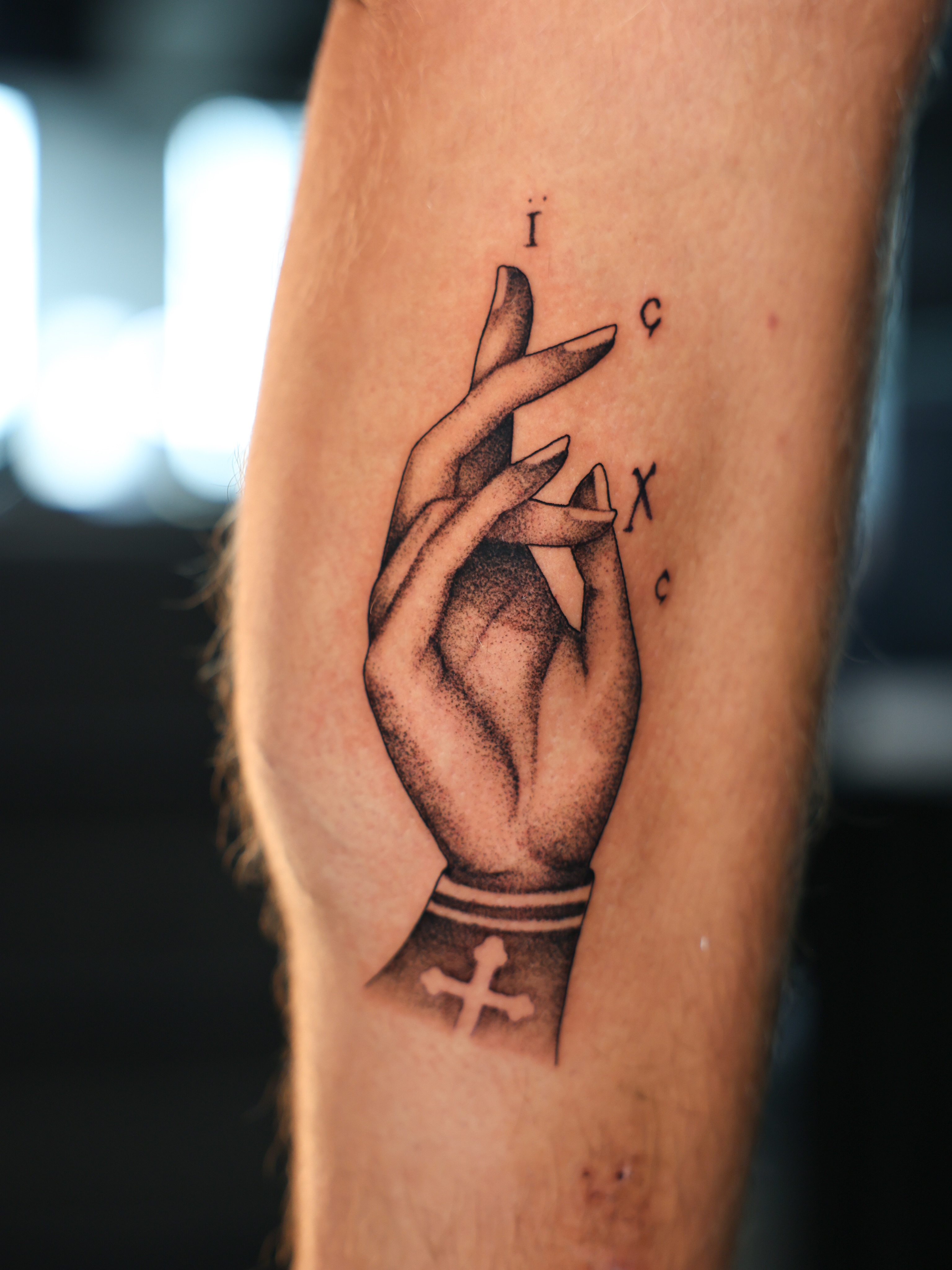 Hand with cross dotwork tattoo on the forearm by Hannah Burnside, Charlotte, North Carolina