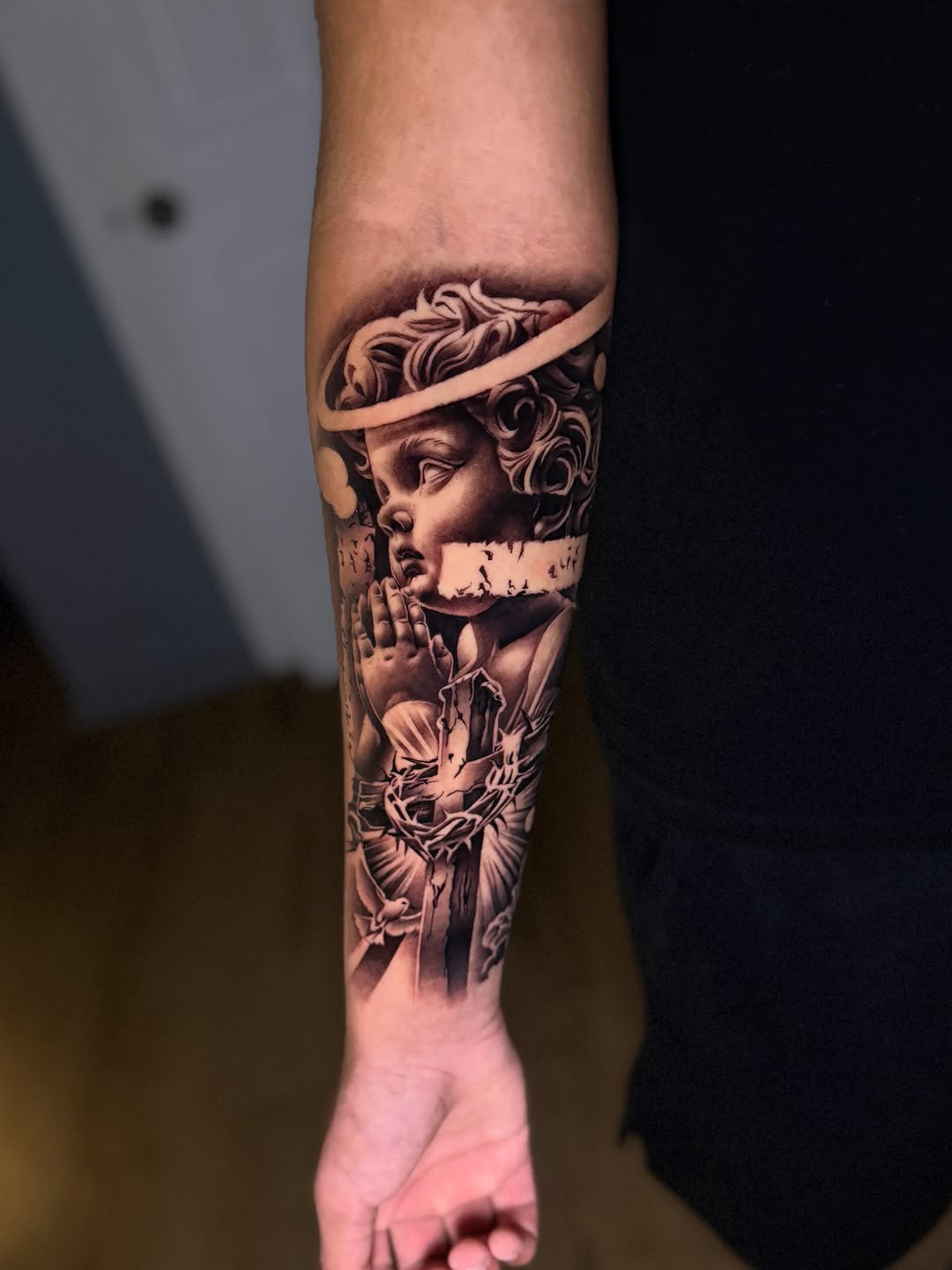 Angel and cross realism tattoo on the forearm by Miles Johnson