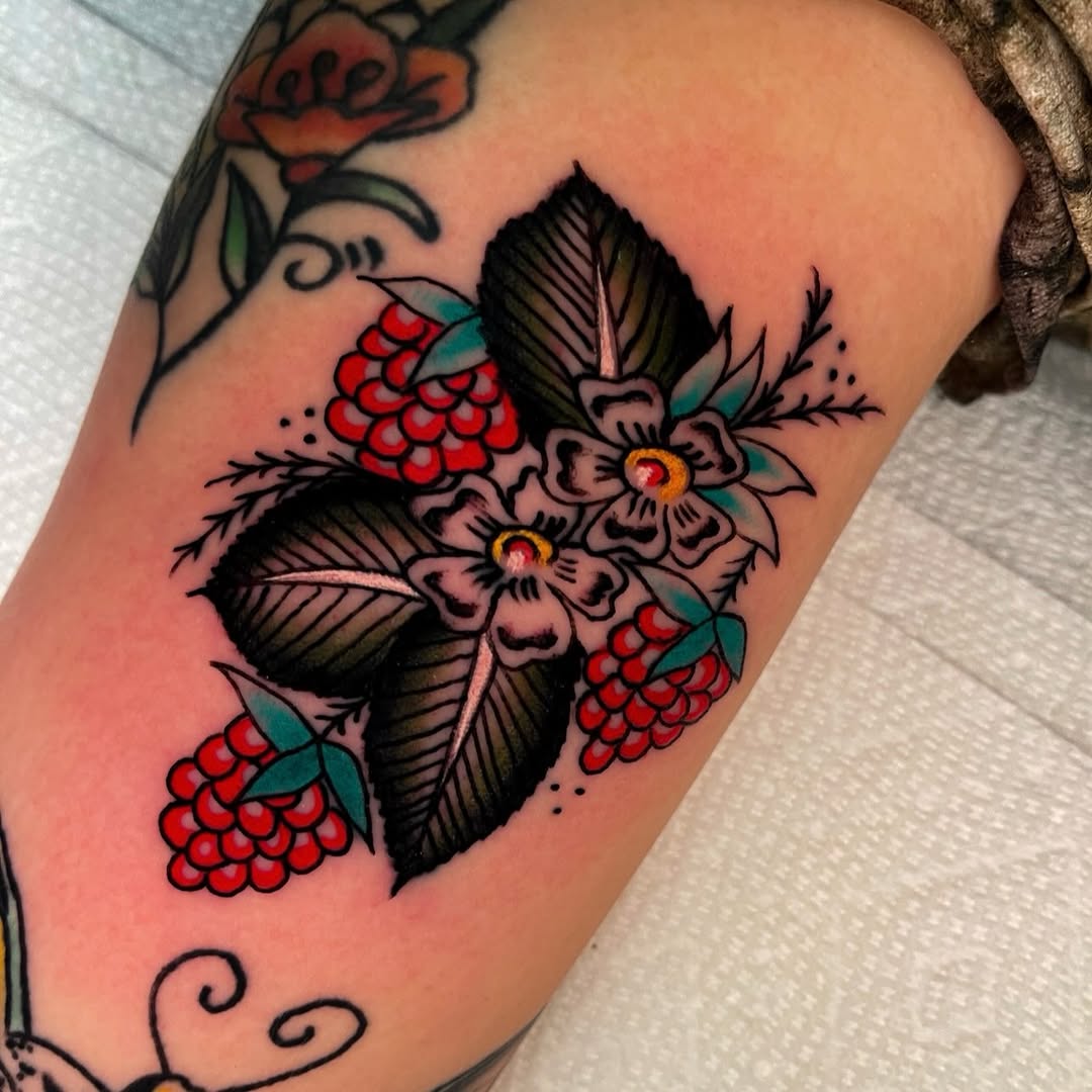 Raspberries and flowers neo-traditional tattoo on the thigh by Devyn Hightower