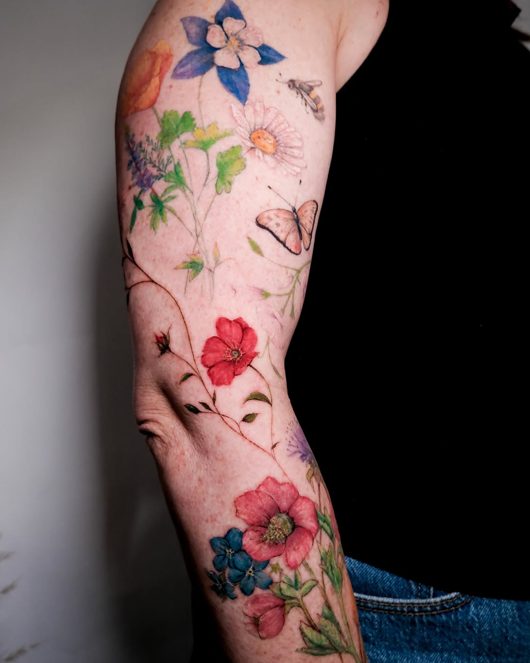 Floral bouquet watercolor tattoo on the forearm by NAS