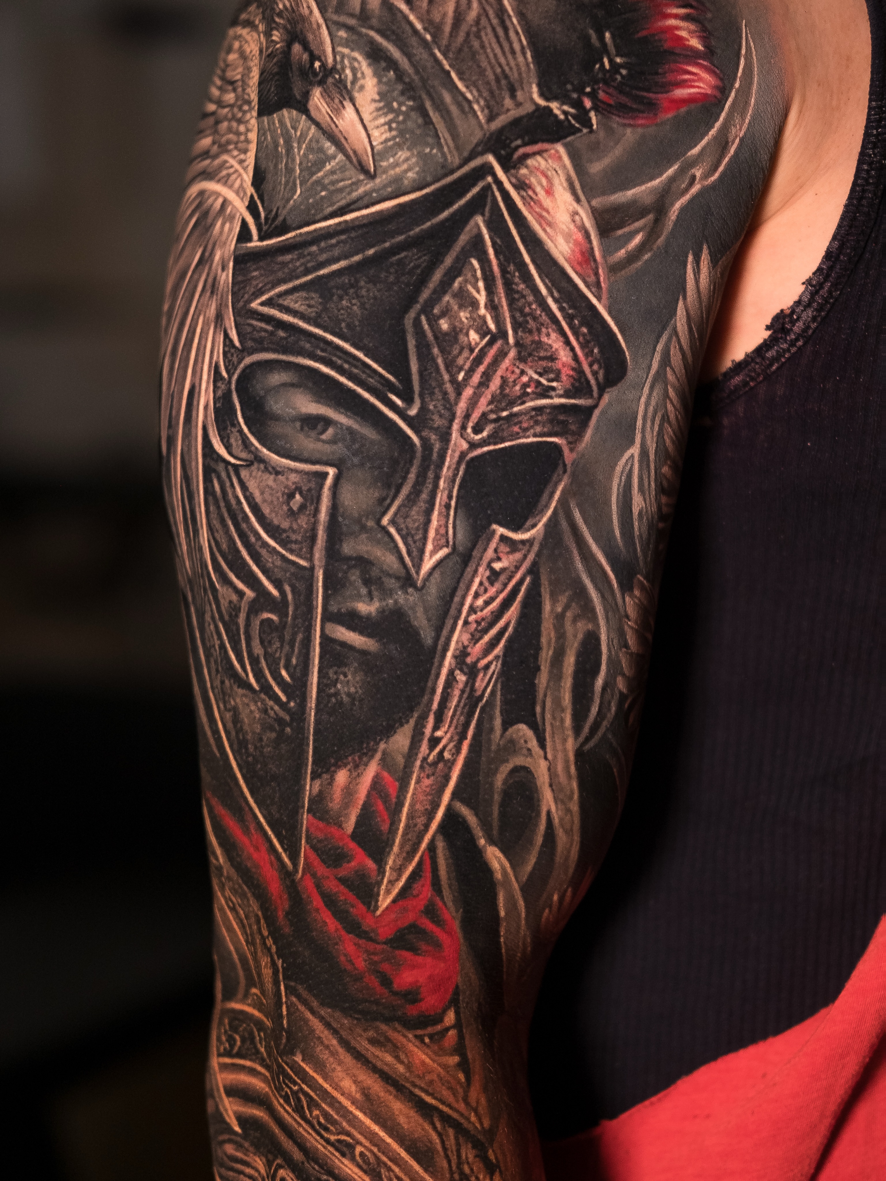 Spartan warrior helmet with raven realism tattoo on the upper arm by Christopher Powell