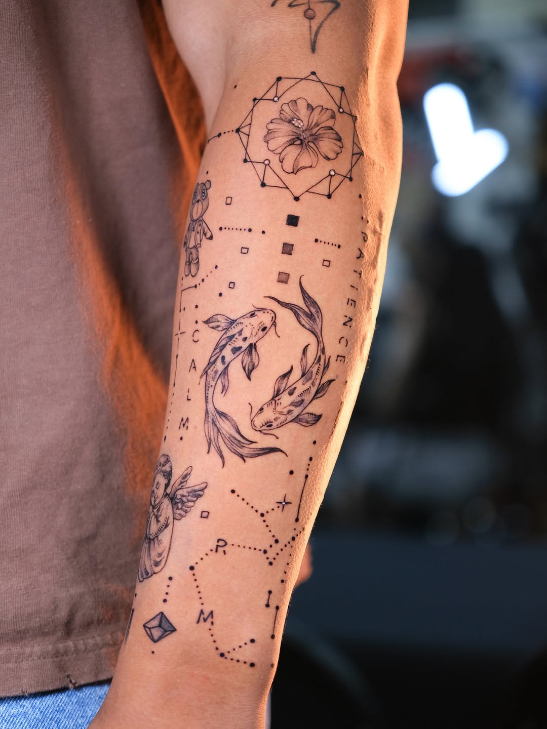 Koi fish and celestial elements minimalist tattoo on the forearm by Tattoo Miami π
