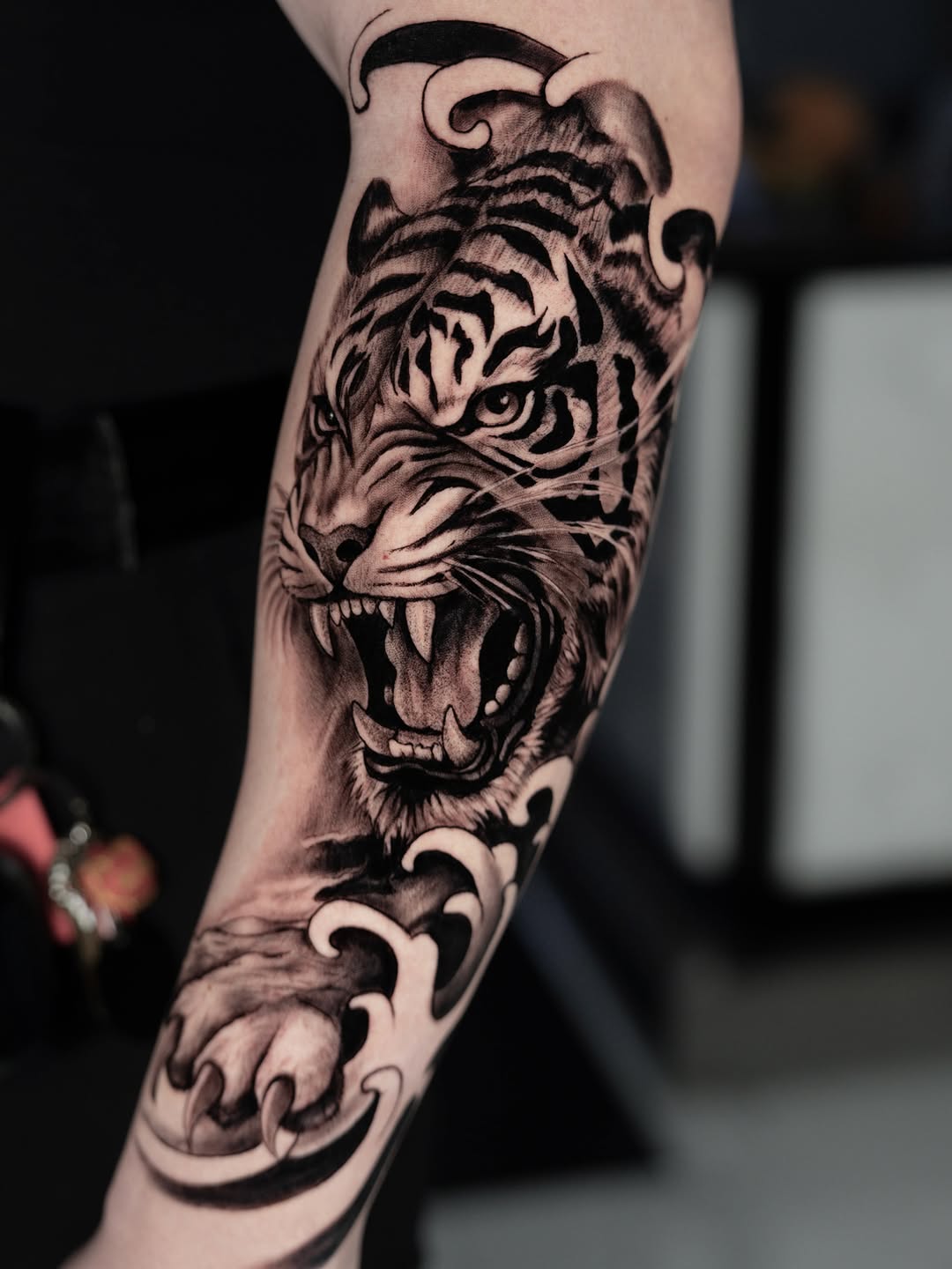 Roaring tiger with waves realism tattoo on the forearm by Idalia Pulido