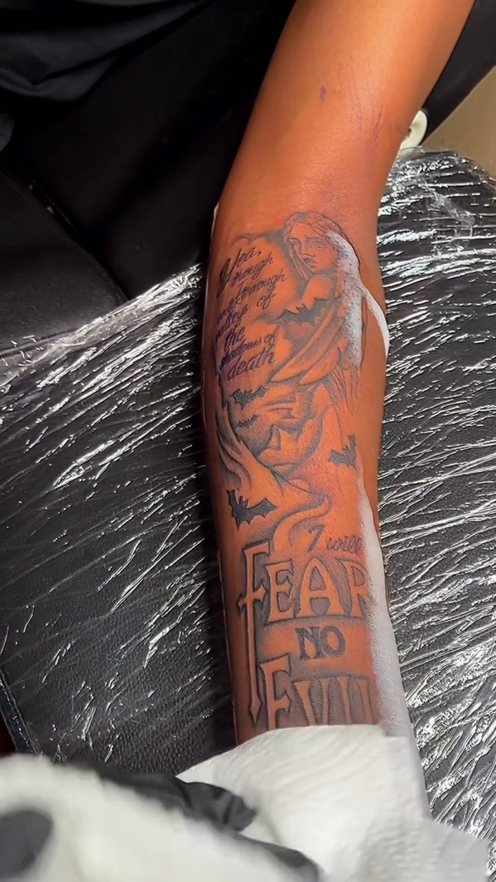 Angel with "Fear No Evil" text Chicano tattoo on the upper arm by Detroit tattoo Artist