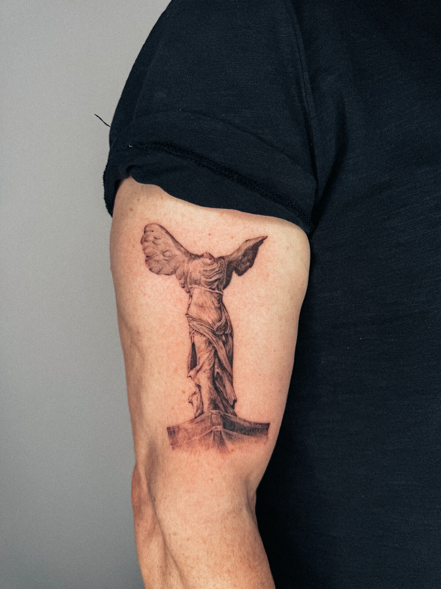 Statue black and grey tattoo on the forearm by Emma- Los Angeles Tattoo Artist