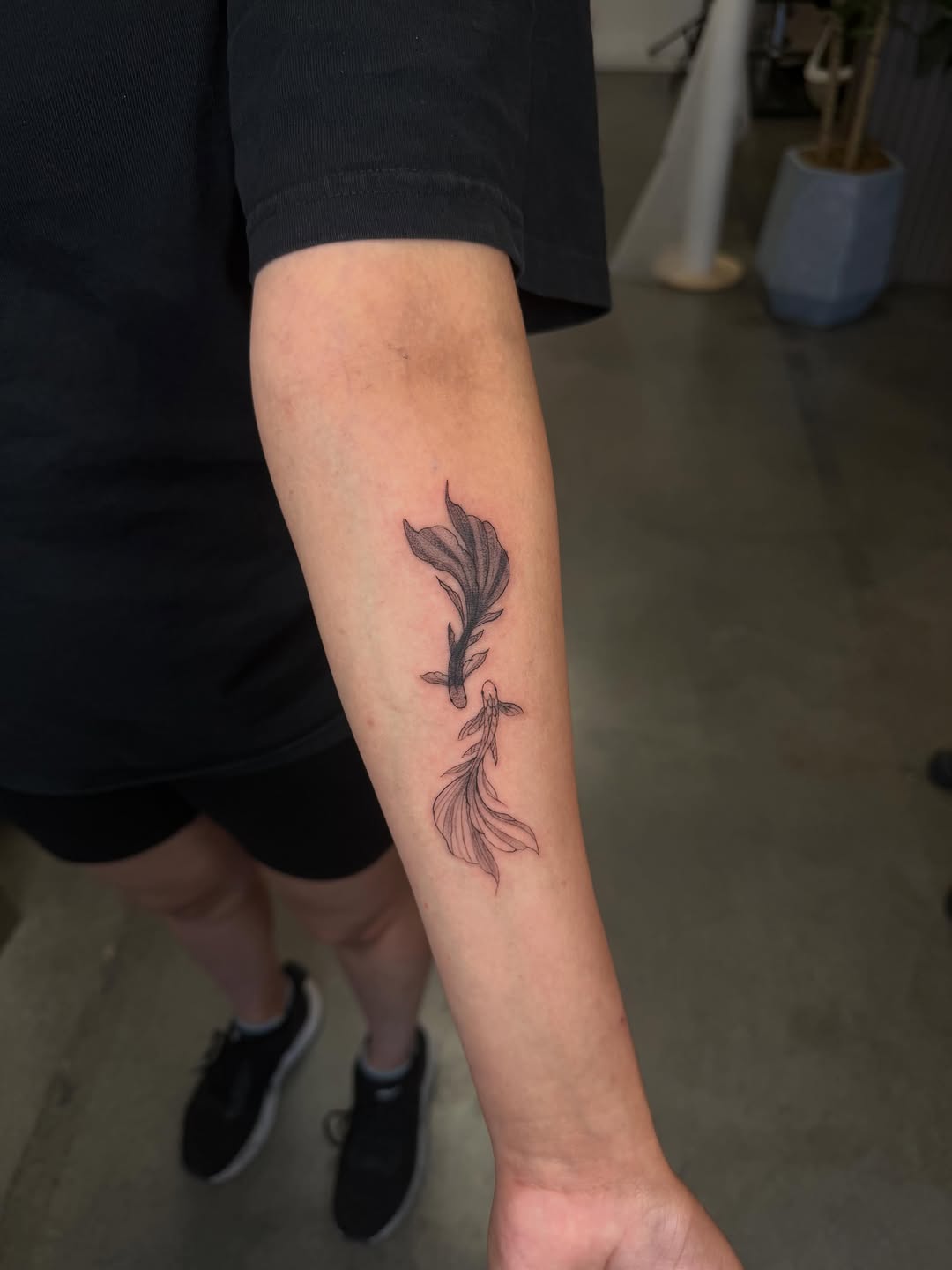 Two betta fish fine line tattoo on the forearm by Lxx.