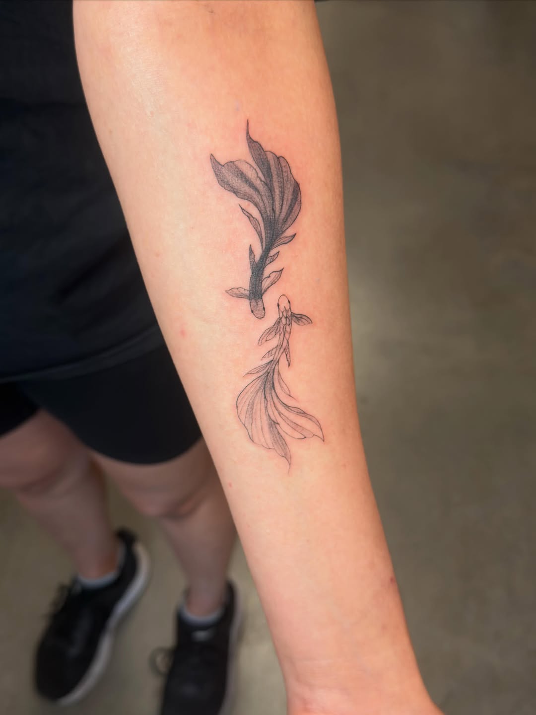 Two betta fish fine line tattoo on the forearm by Lxx.
