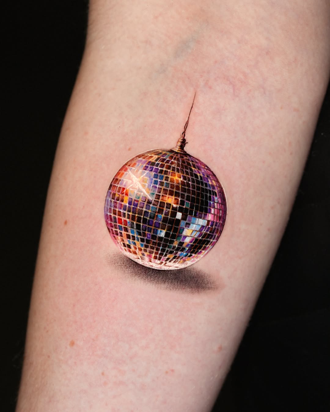 Disco ball watercolor tattoo on the forearm by Gody