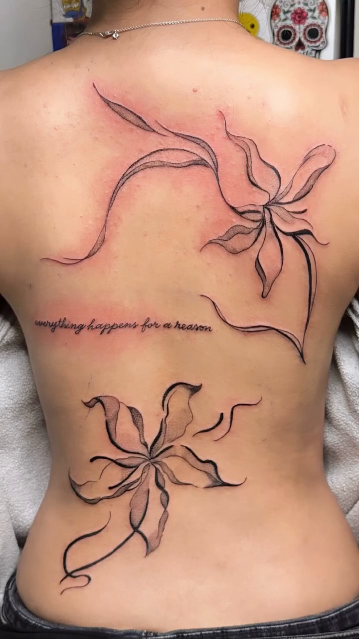 Two flowers and script blackwork tattoo on the back by Engel Zurc