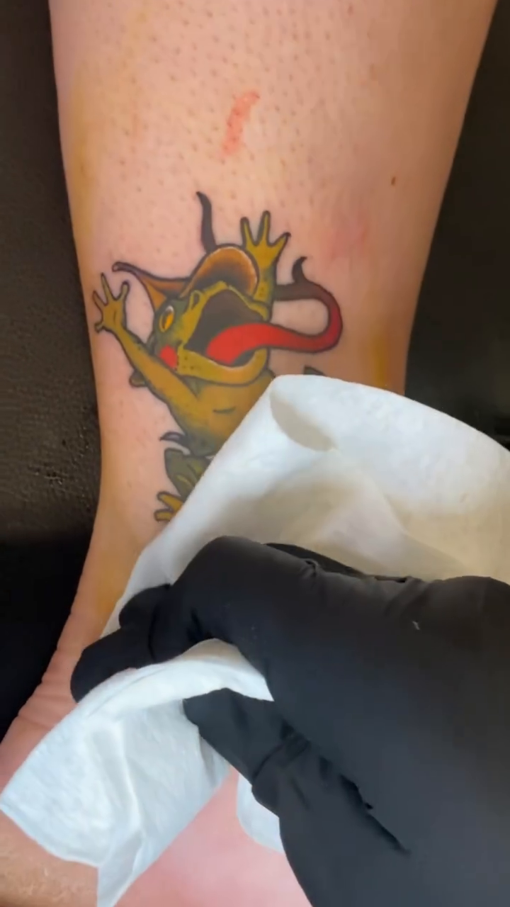 Cartoon frog character tattoo American traditional tattoo on the leg by Ian Dorman