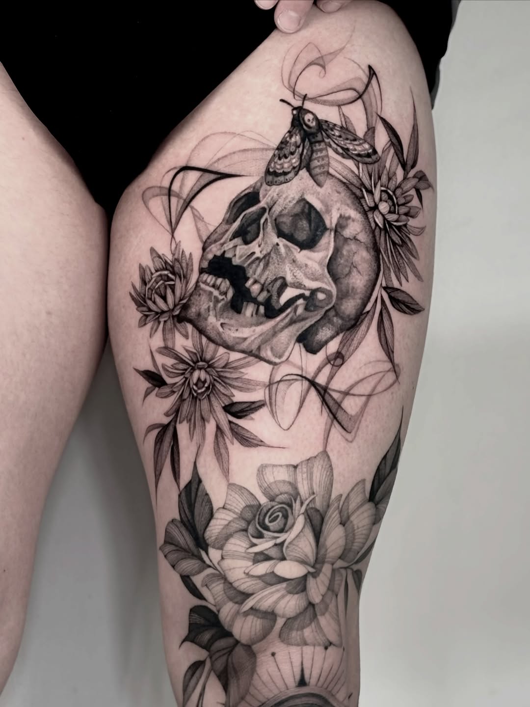 Skull with moth and roses sketch tattoo on the thigh by Brittney Naami, San Francisco, California