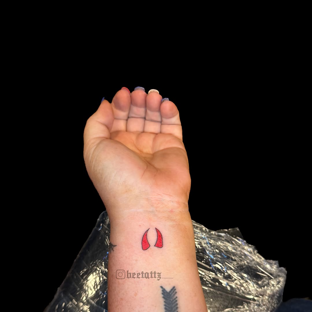 Devil horns tattoo on the forearm by Brinkley McGill