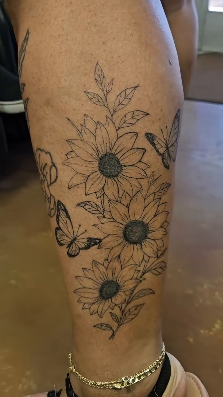 Sunflowers and butterflies on leg fine line tattoo on the leg by Mischief π€