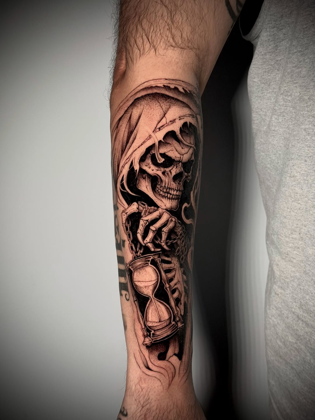 Grim reaper holding hourglass realism tattoo on the forearm by Kbtattz