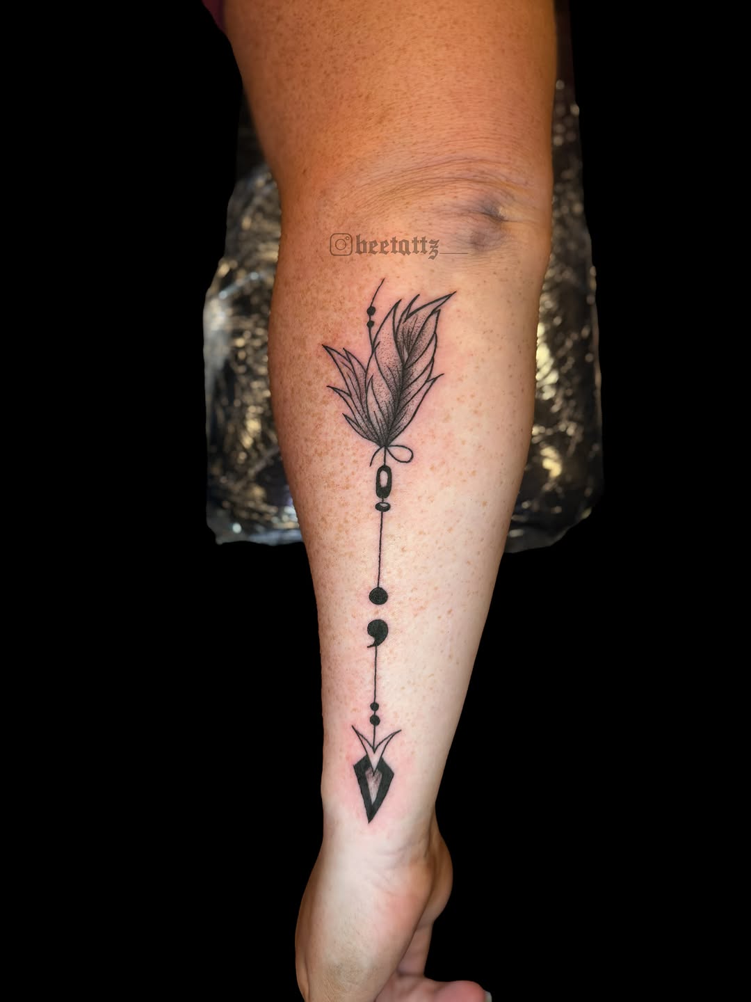Feather and arrow tattoo on the forearm by Brinkley McGill