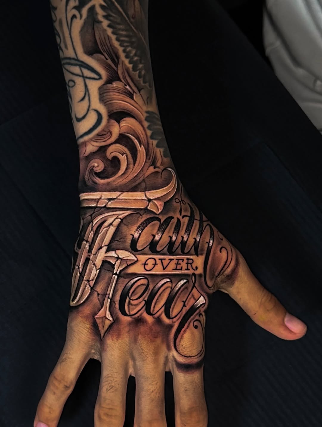 Faith over Fear lettering lettering tattoo on the hand by Omar Sheriff Herrera