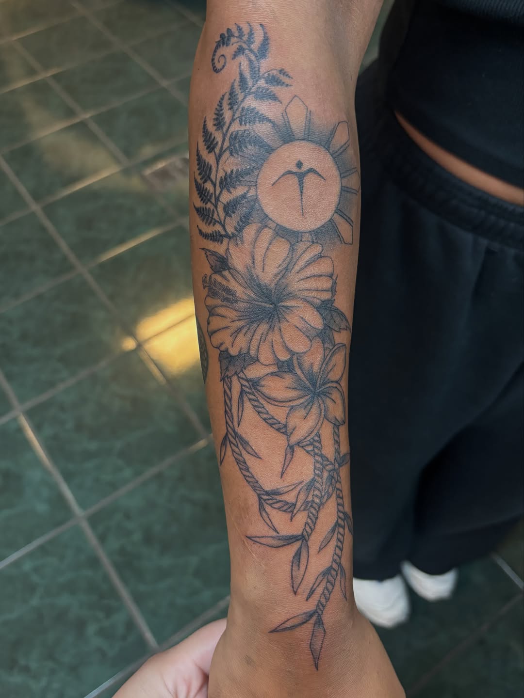 Philippine sun with flowers and fern fine line tattoo on the forearm by ✨Tattoos By Martina ✨