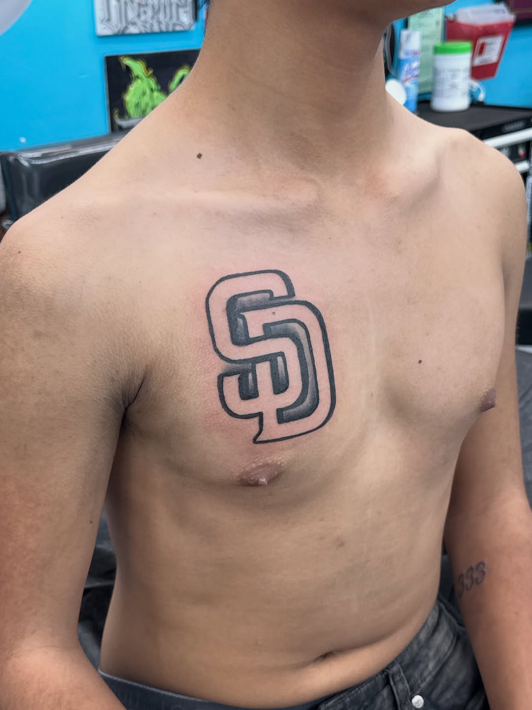 SD logo tattoo on the chest by ⠀Greave