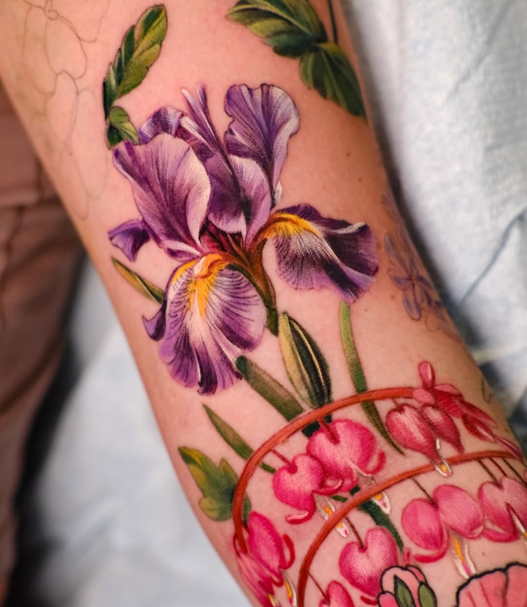 Iris and bleeding hearts flowers watercolor tattoo on the forearm by Andres Acevedo, Denver, Colorado