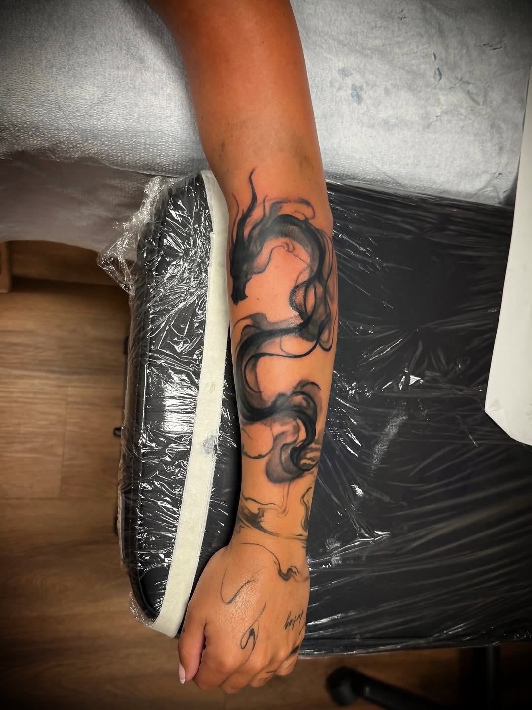 Smoke dragon blackwork tattoo on the forearm by Julian Olson