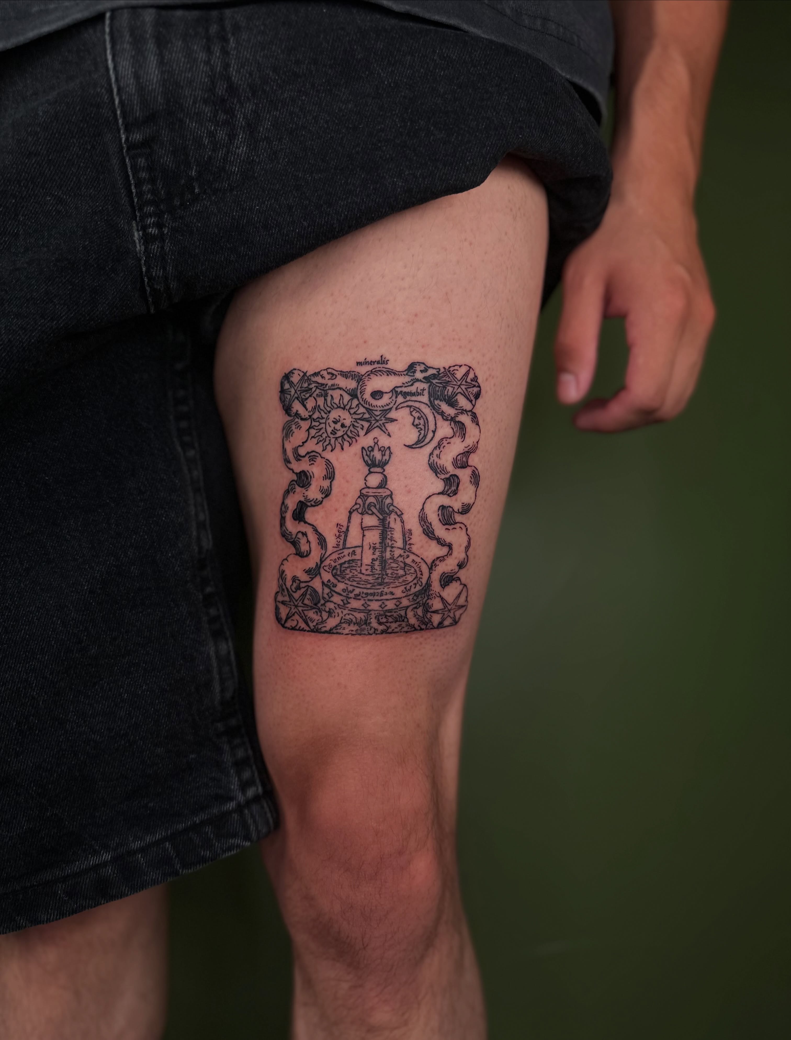Fountain with celestial symbols black and grey tattoo on the thigh by Nikolas Tapio Aatos Mäkelä