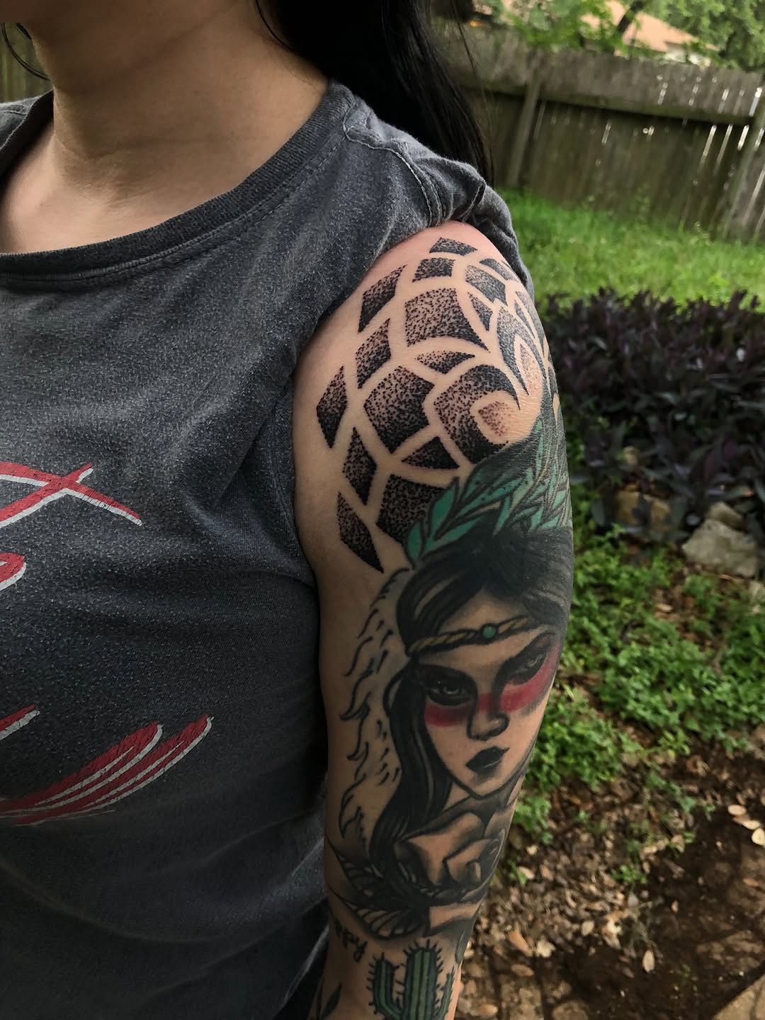 Woman's face with geometric pattern ornamental tattoo on the upper arm by James ⚡️ Tattoo Artist