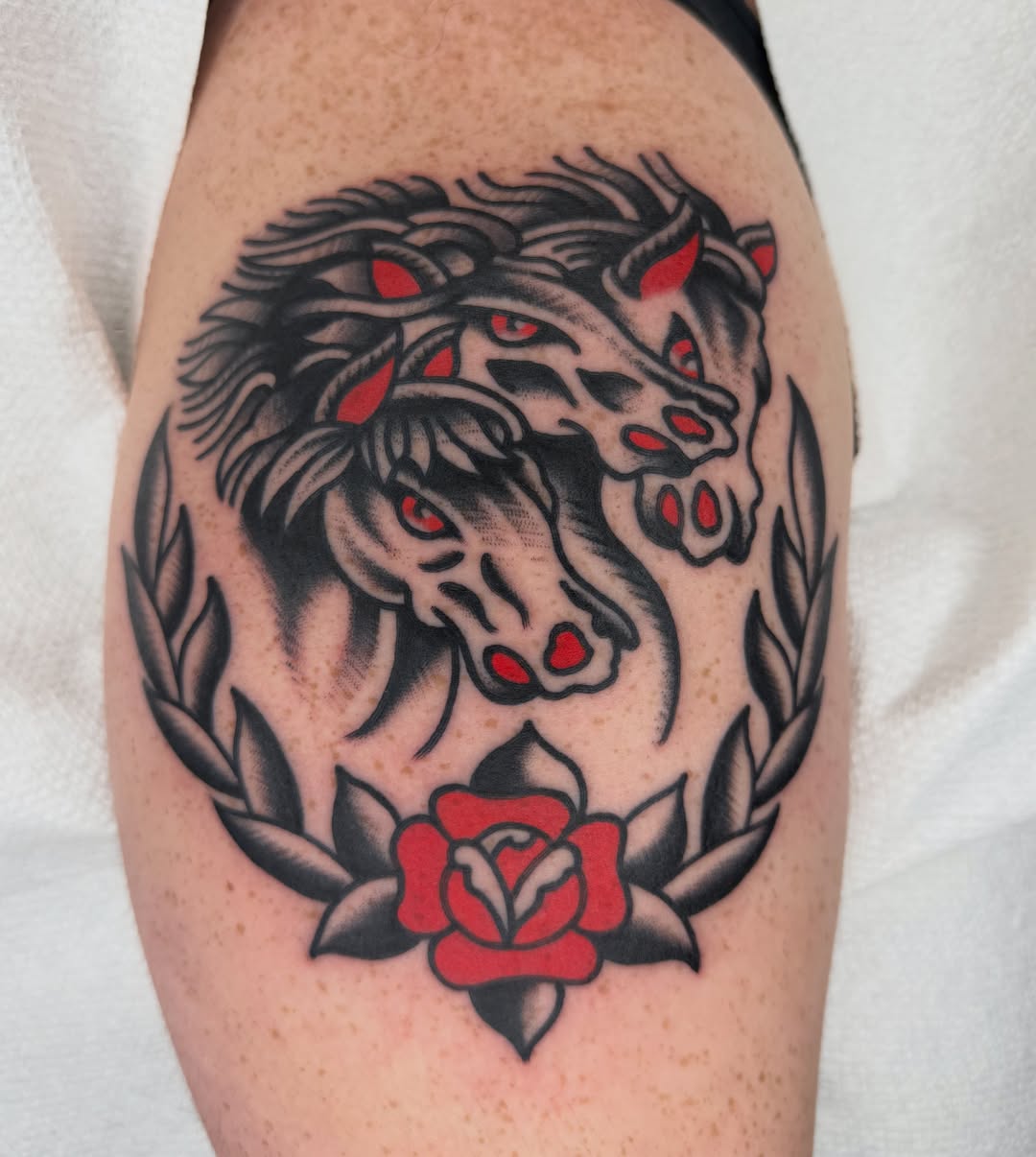 Wolf heads and rose American traditional tattoo on the forearm by لا Kenny McCabe لا