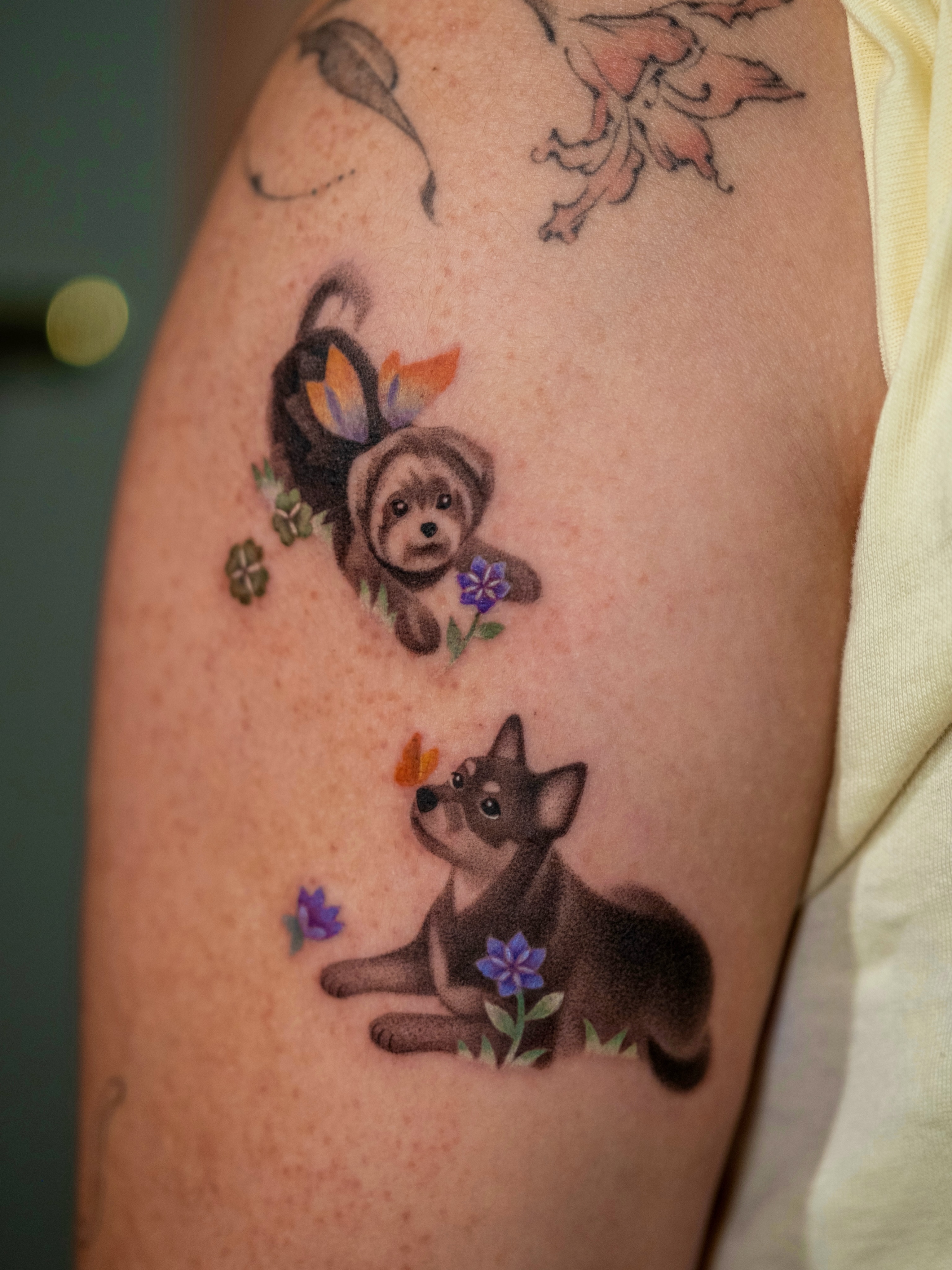 Dogs and flowers dotwork tattoo on the forearm by Toki