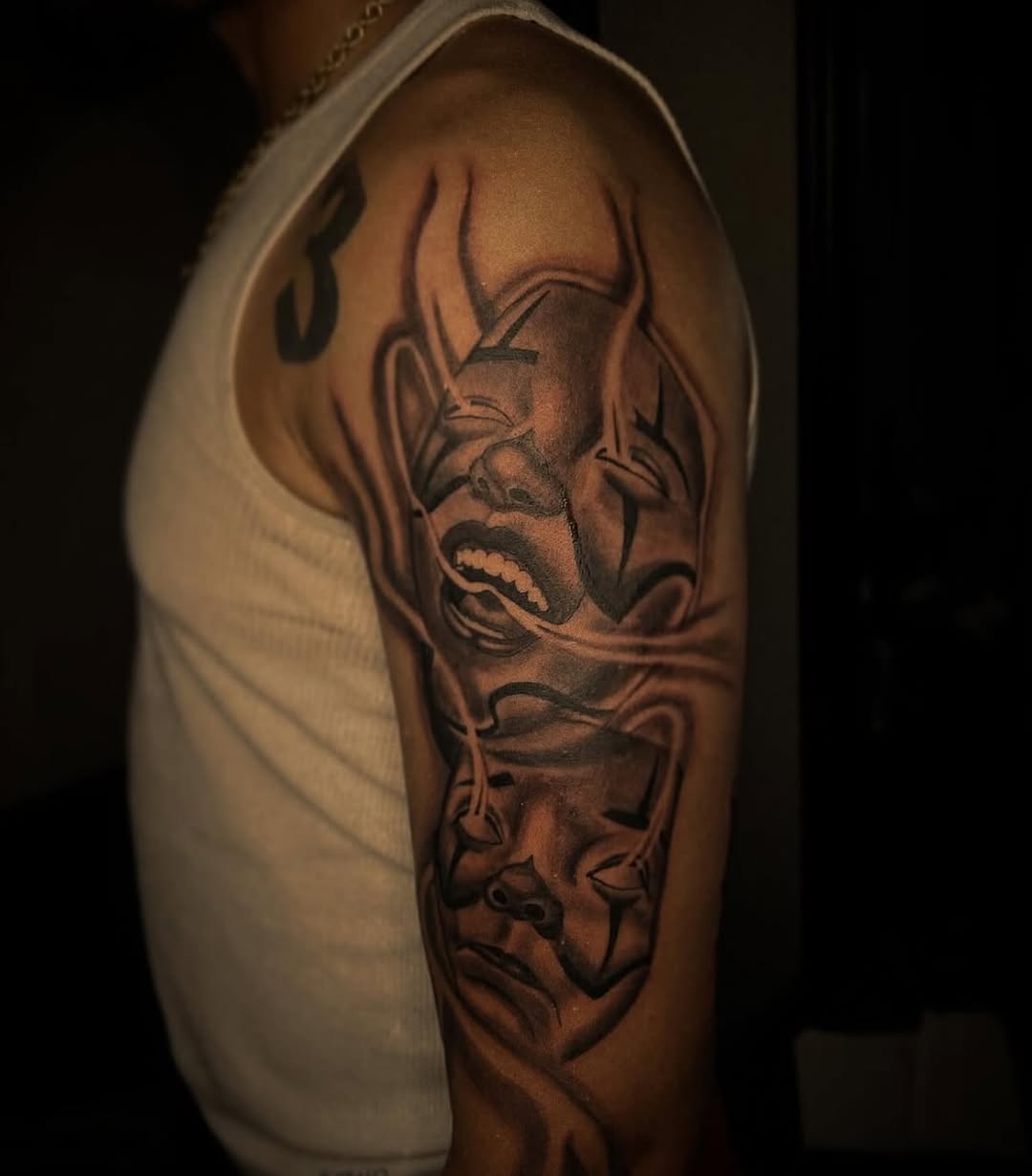 Two clown faces realism tattoo on the upper arm by @tattsbyleek