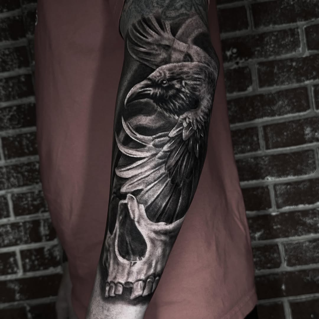 Raven and skull realism tattoo on the forearm by Jeremiah Warner