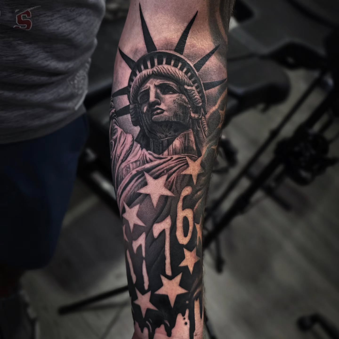 Statue of liberty black and grey tattoo on the forearm by Julia Oravets
