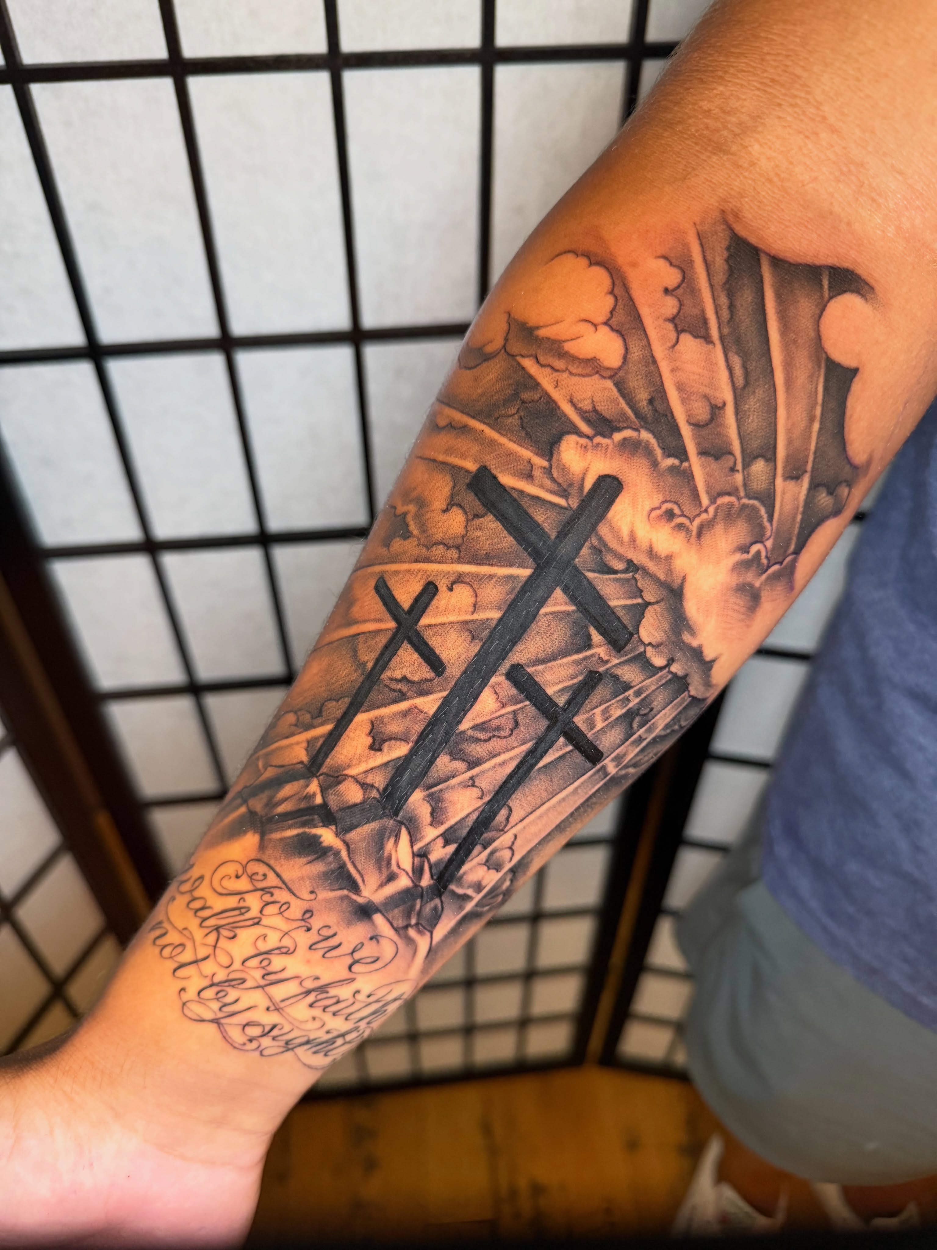 Crosses and clouds realism tattoo on the forearm by Kevin R. Onley