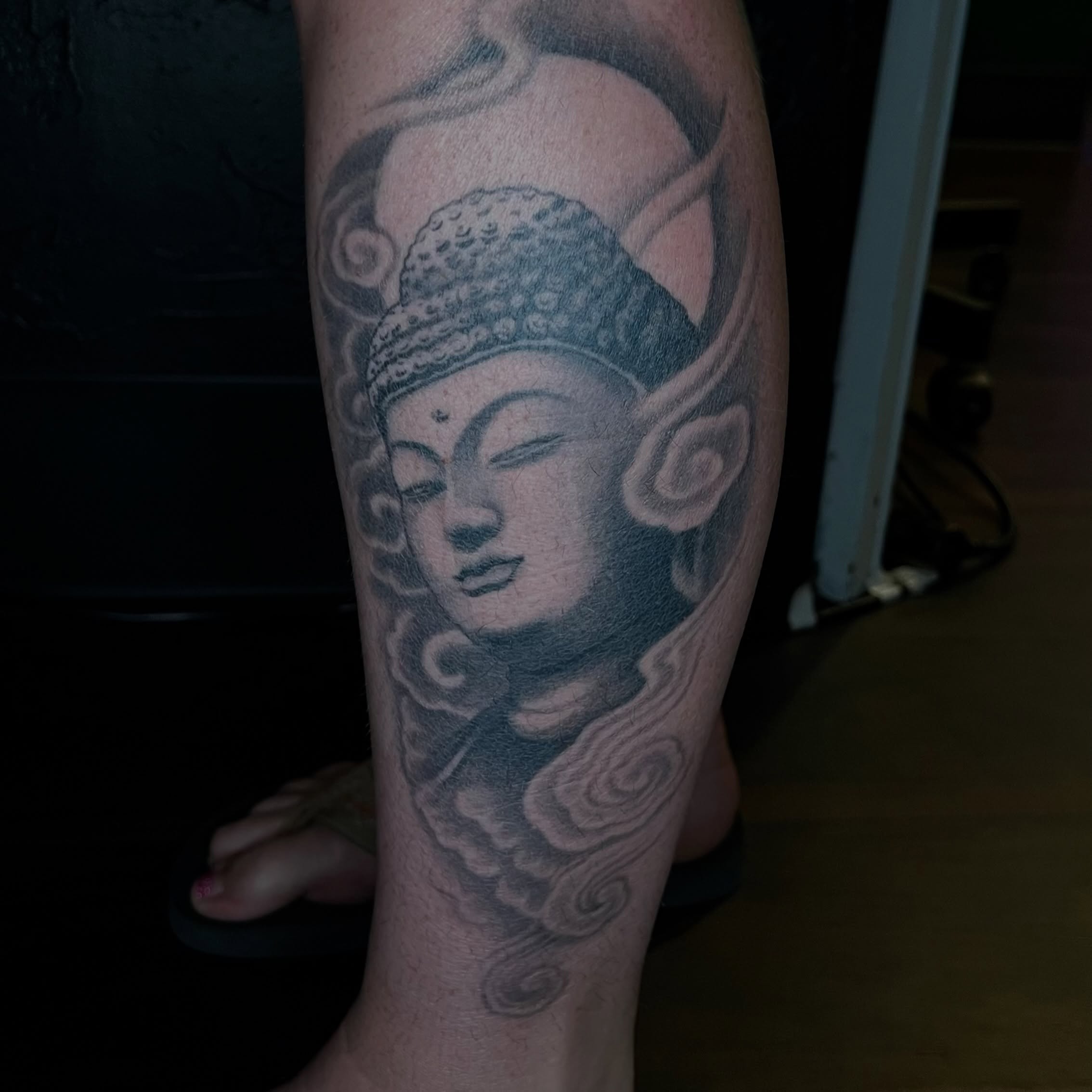 Buddha head black and grey tattoo on the forearm by Vic Merkley