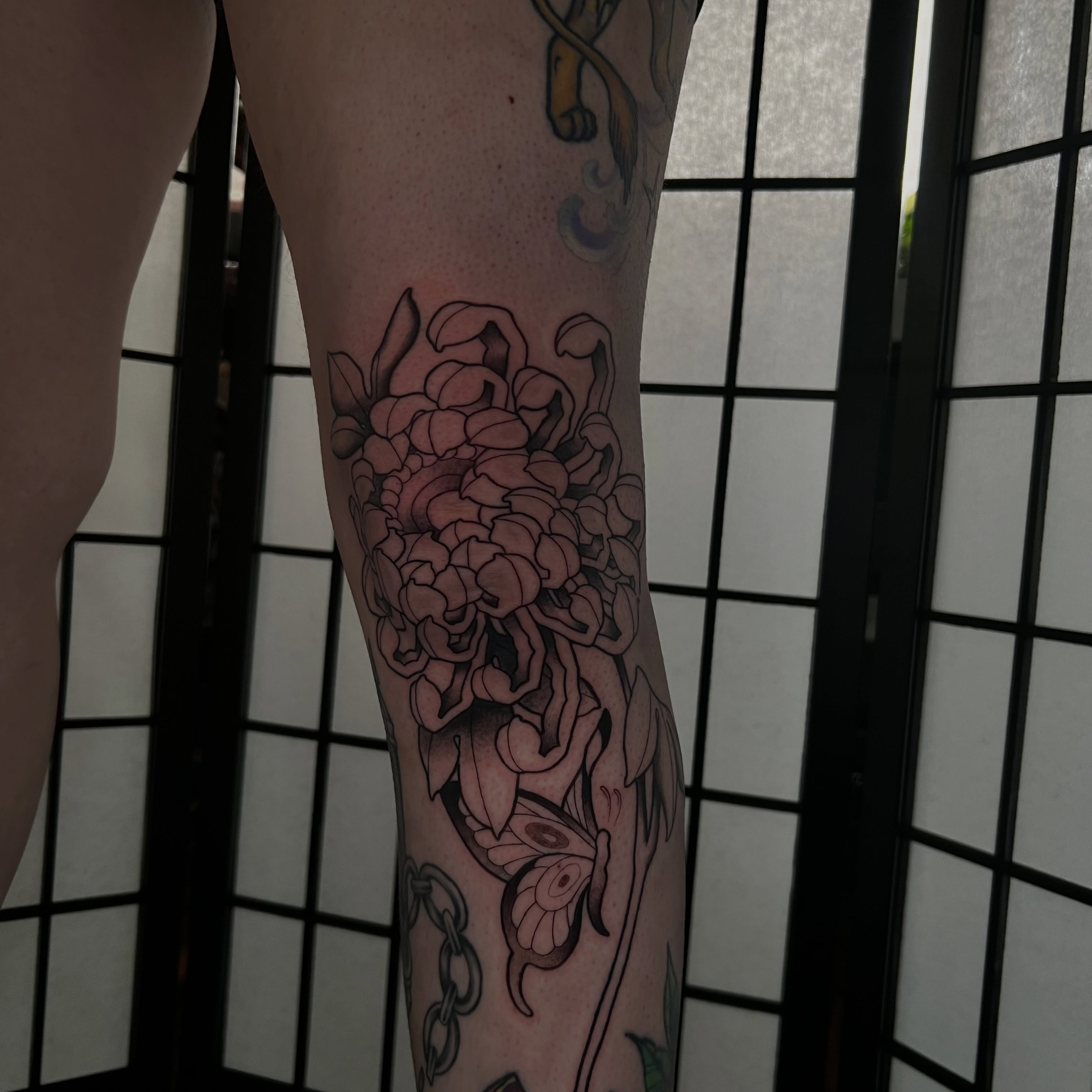 Chrysanthemum bouquet black and grey tattoo on the forearm by Vic Merkley