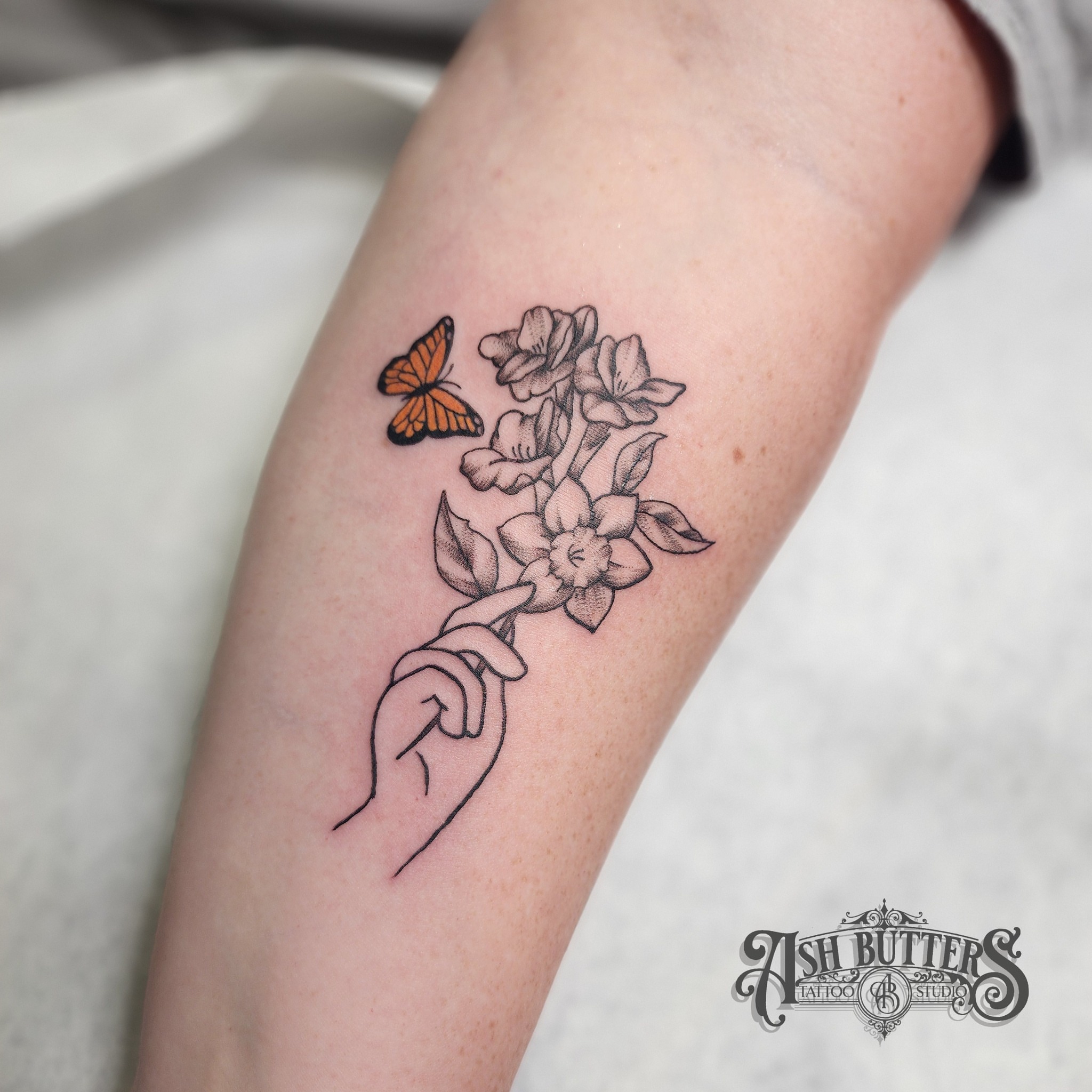 Butterfly and flowers dotwork tattoo on the forearm by Ash Butters