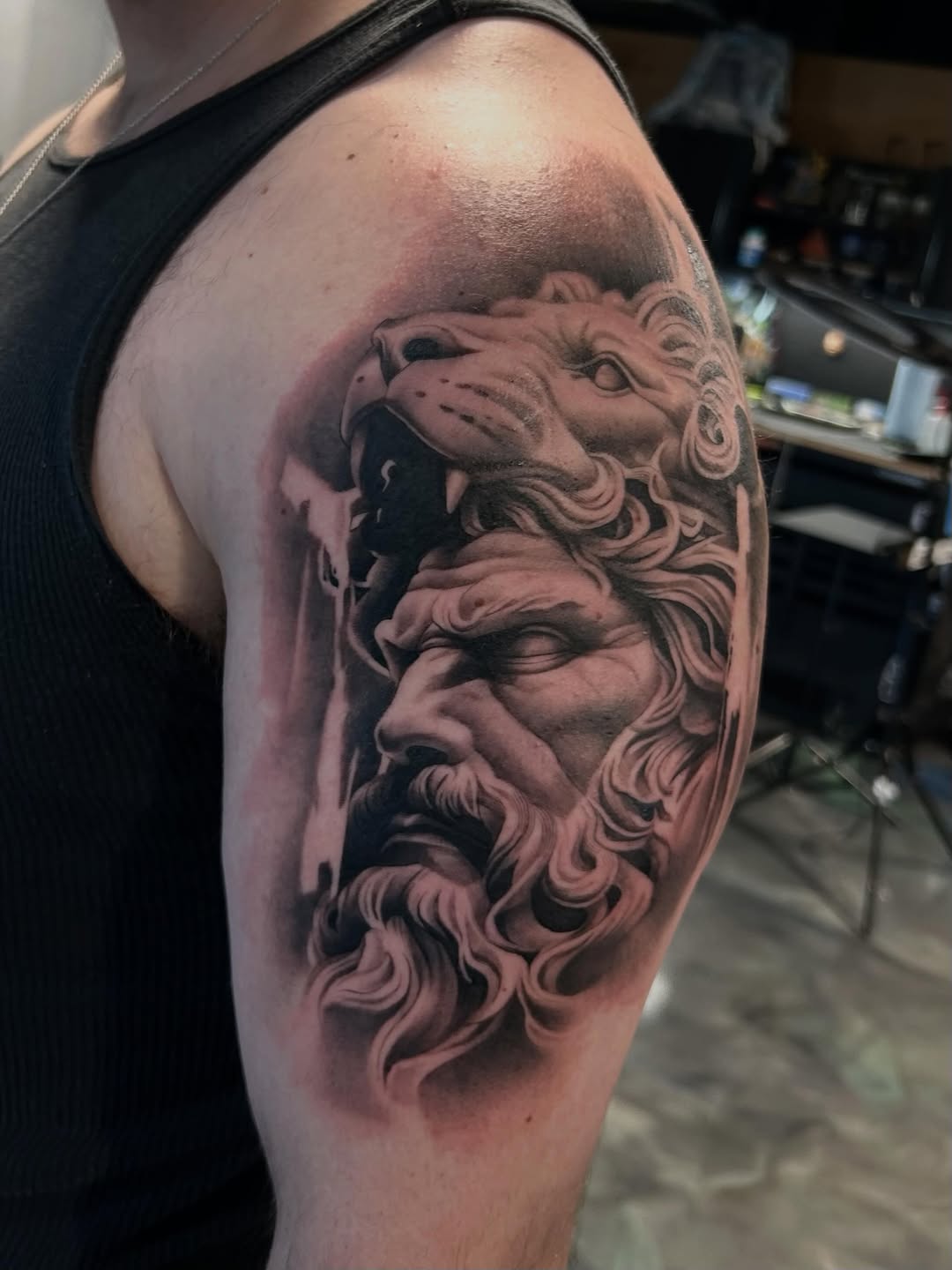Man with lion headdress surrealism tattoo on the shoulder by Dallas Corsmeier