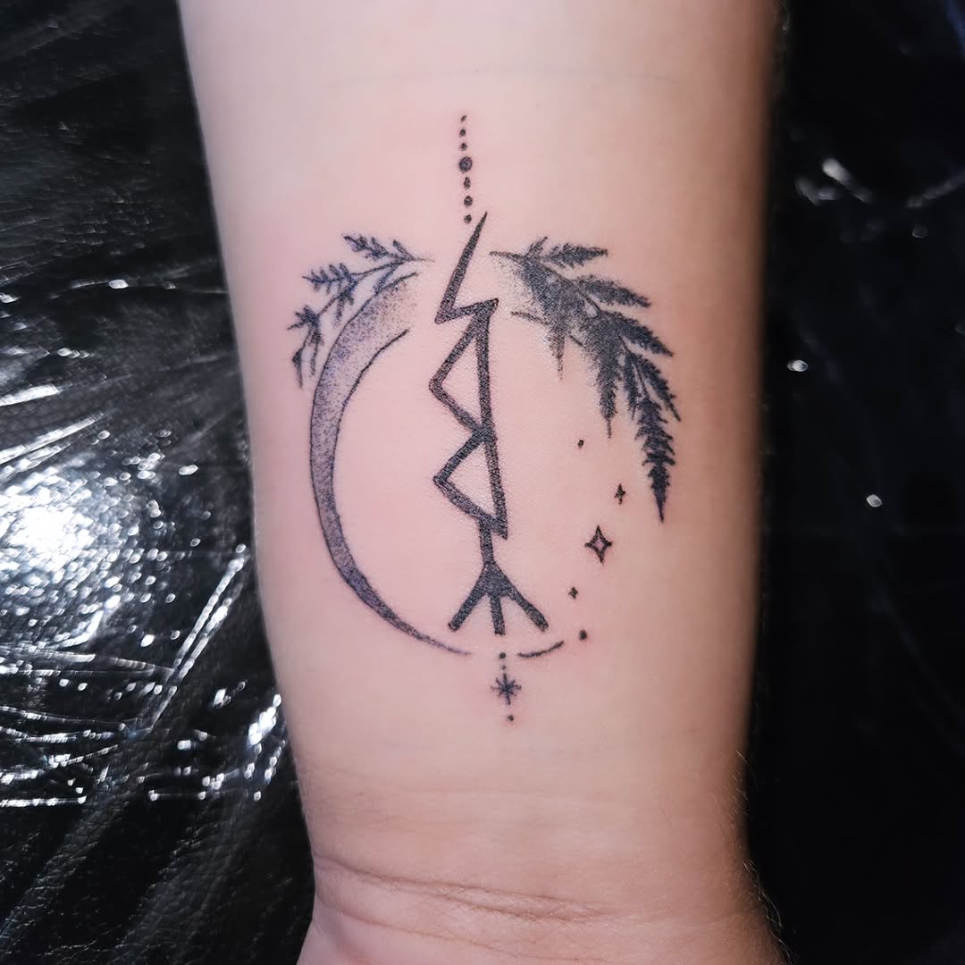 Rune with moon and foliage ornamental tattoo on the forearm by Mischief π€