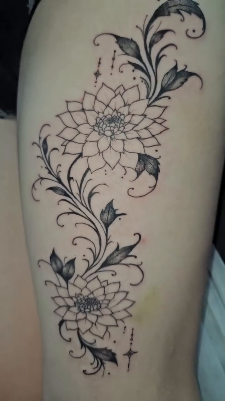 Floral vine with two flowers ornamental tattoo on the thigh by Mischief π€