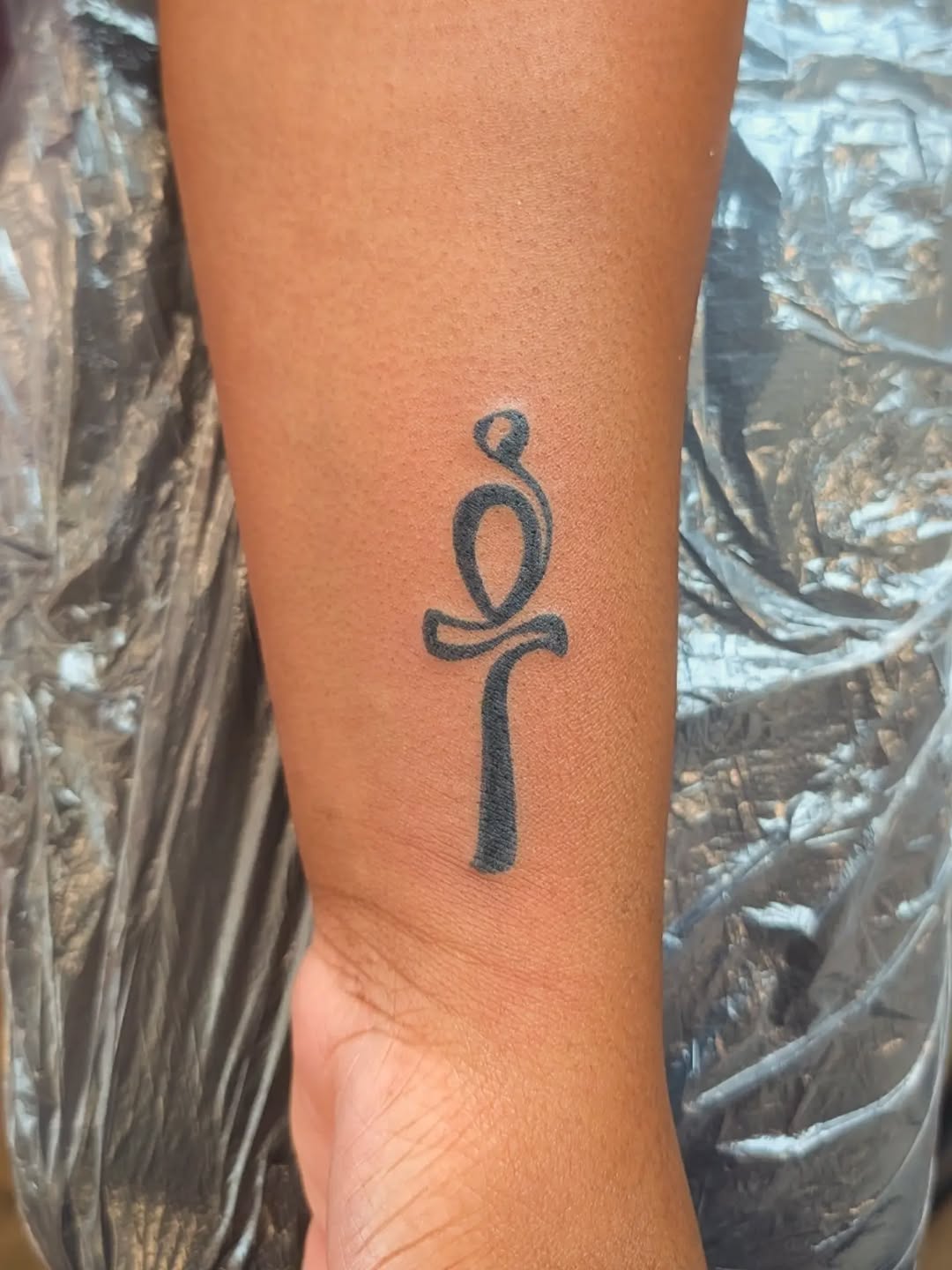 Ankh symbol tattoo on the forearm by Nenookaasi Martin