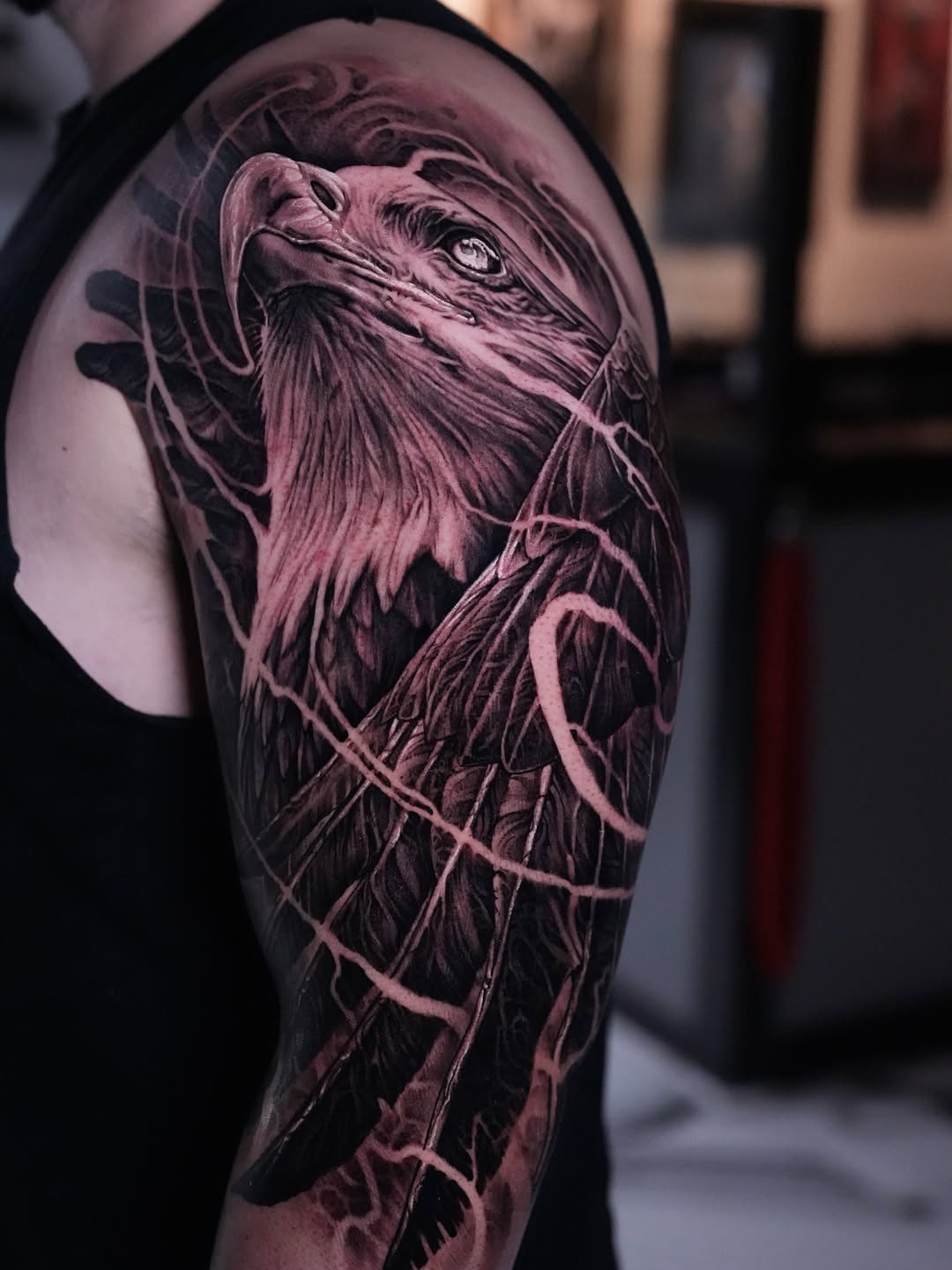 Eagle head and wings realism tattoo on the upper arm by Nico Perez