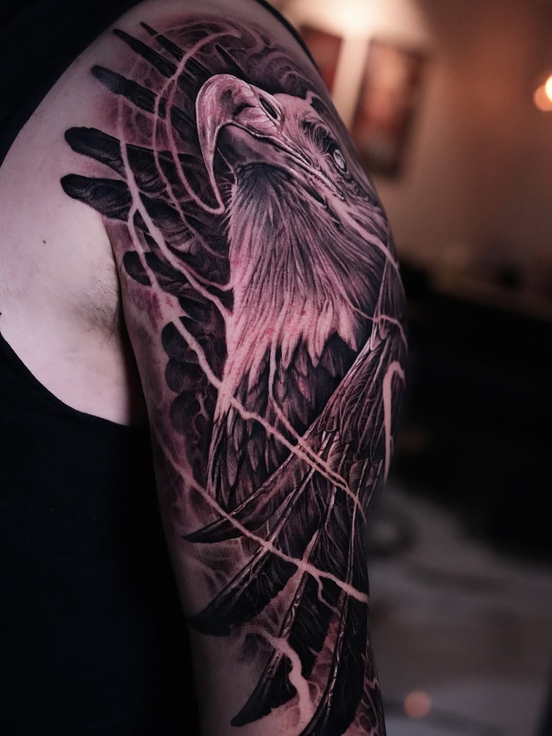 Eagle head and wings surrealism tattoo on the upper arm by Nico Perez