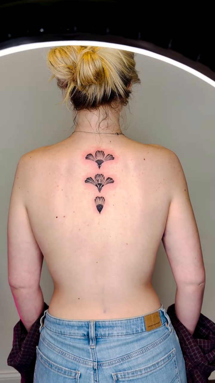 Floral spine tattoo blackwork tattoo on the back by Fine Line Tattoo Artist