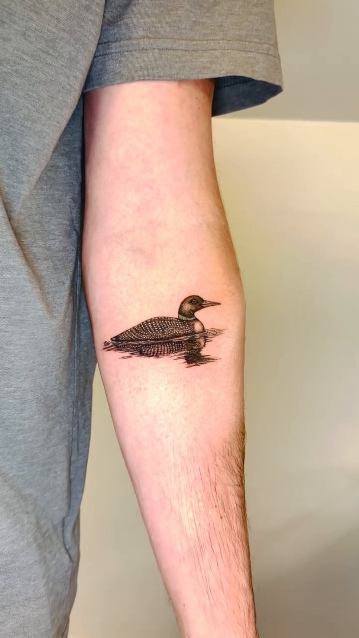 Loon on water fine line tattoo on the forearm by Fine Line Tattoo Artist