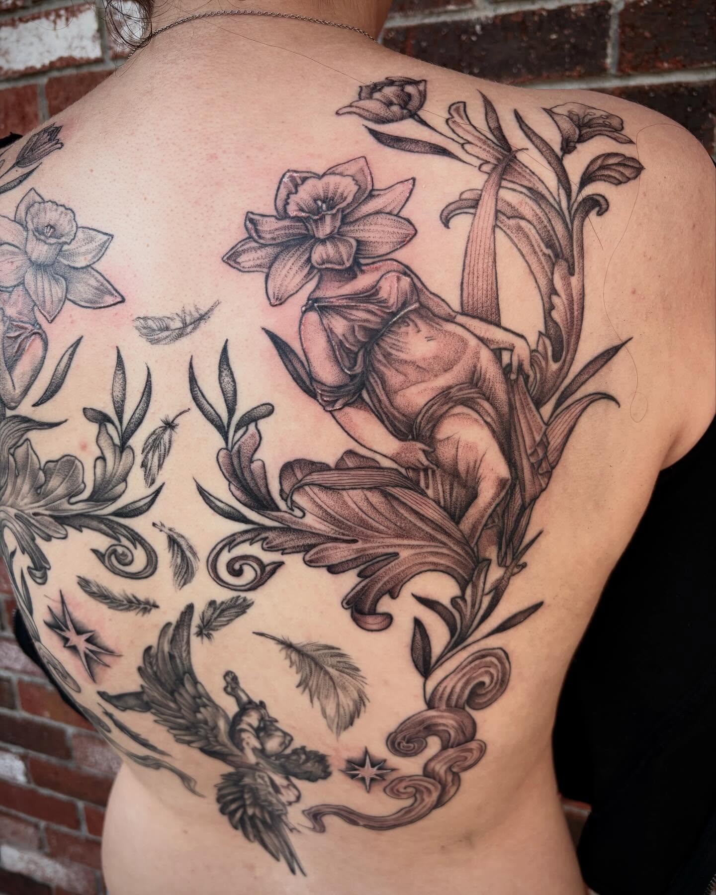 Floral and angelic realism tattoo on the back by Emily Falkowski