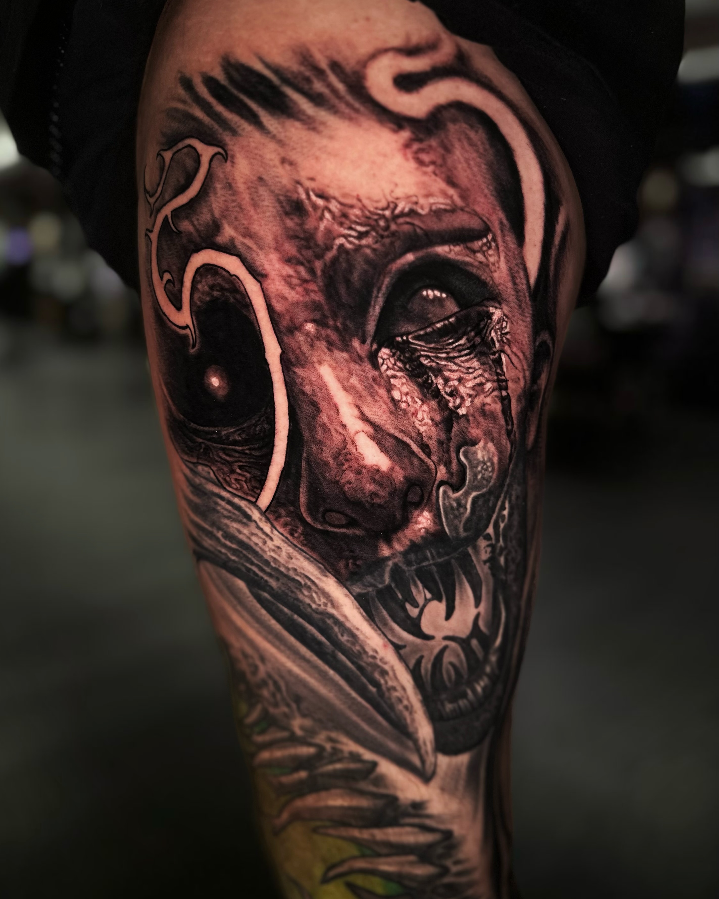 Demonic face with tears realism tattoo on the forearm by Jesse White, Mentor, Ohio