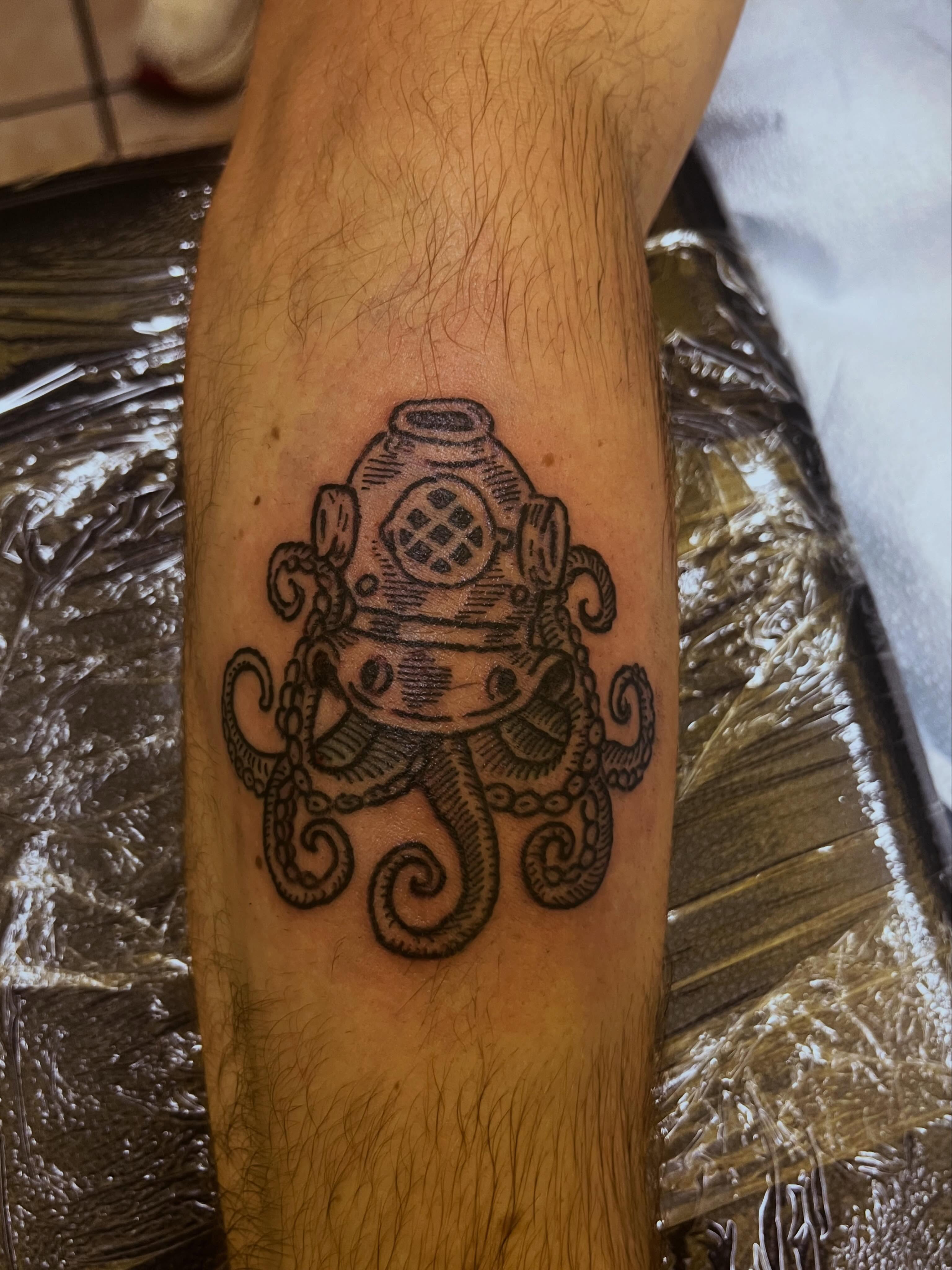 Diving helmet with tentacles American traditional tattoo on the forearm by Rafaela Lopez